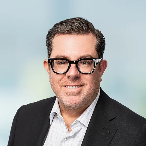 A photo of attorney Derek Sachs against a softly blurred office background