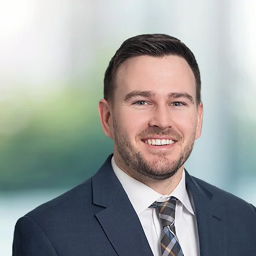 A photo of attorney, Tate Hughes, against a softly blurred office background.