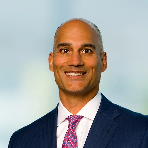 A photo of attorney Vijay Mago against a softly blurred office background