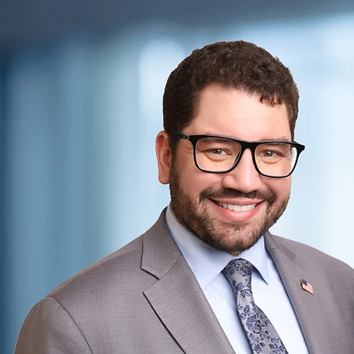 A photo of attorney Paul Carrion against a softly blurred office background