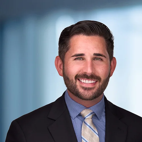 A photo of attorney Ryan Greene against a softly blurred office background.