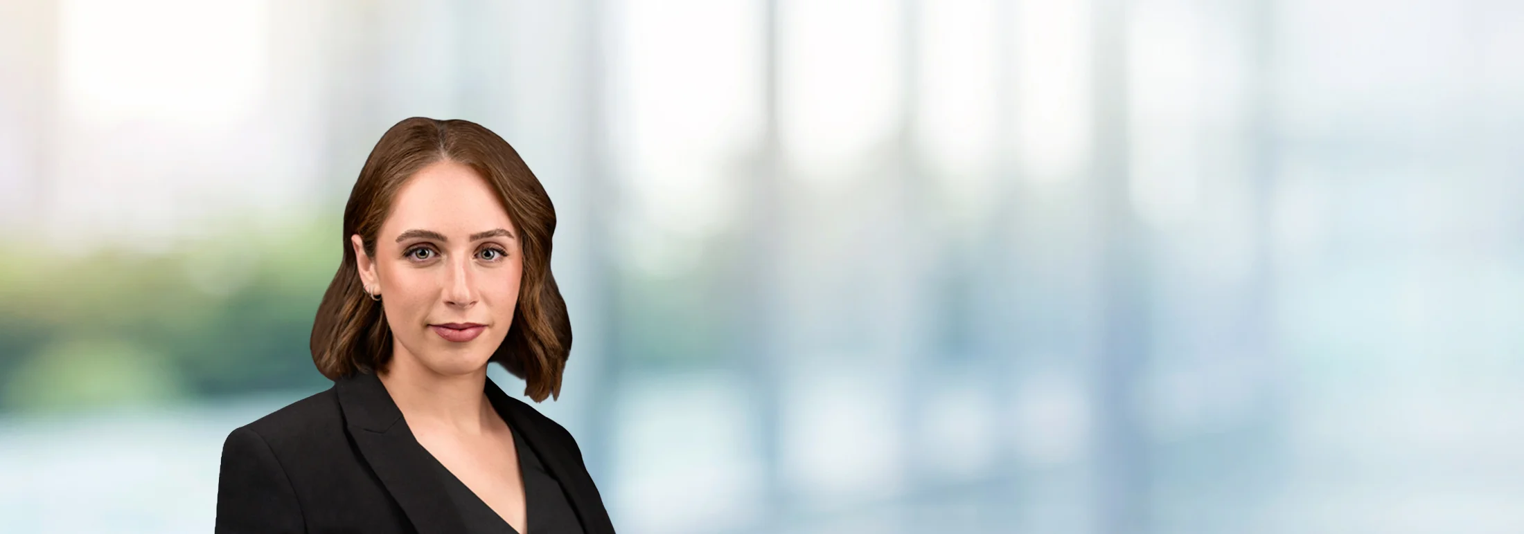 A photo of attorney, Kennedi Fichtel, against a softly blurred office background