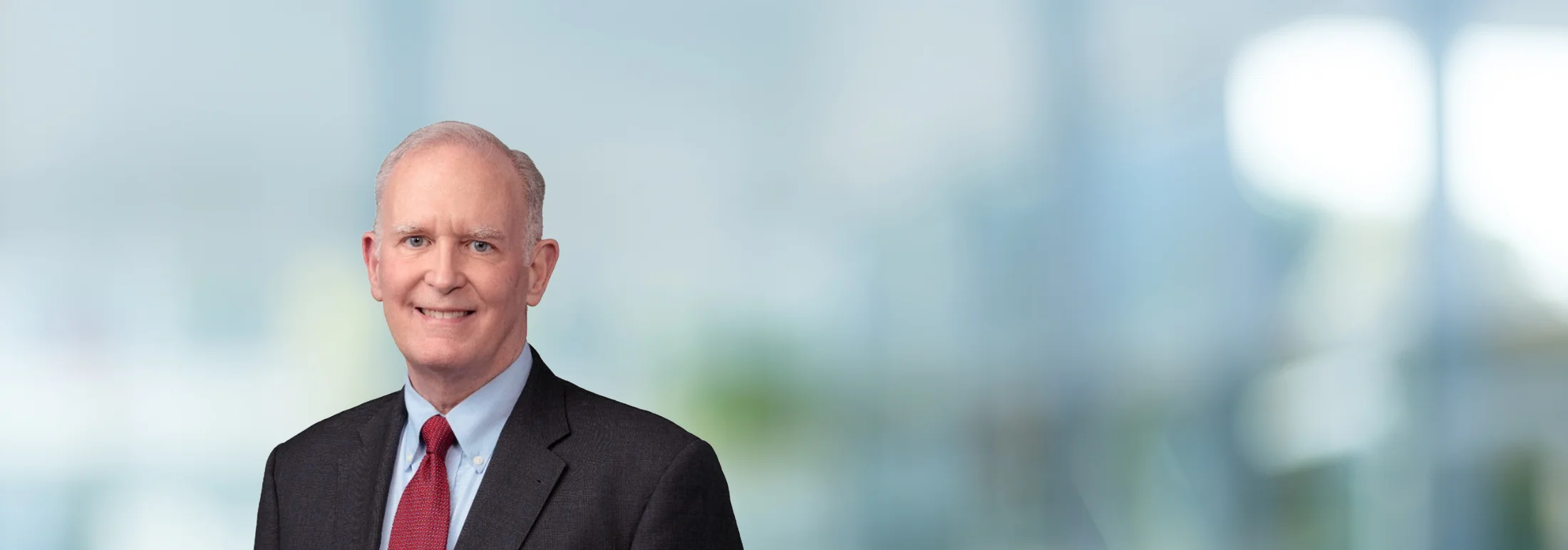 A photo of attorney, Wilhelm Dingler, against a softly blurred office background.