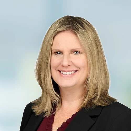 A photo of attorney, Jennifer Sutton, against a softly blurred office background