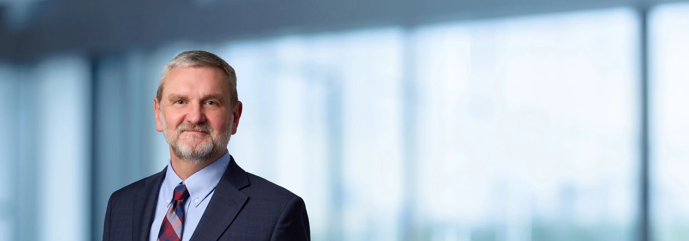 A photo of attorney, John Kreutzer, against a softly blurred office background