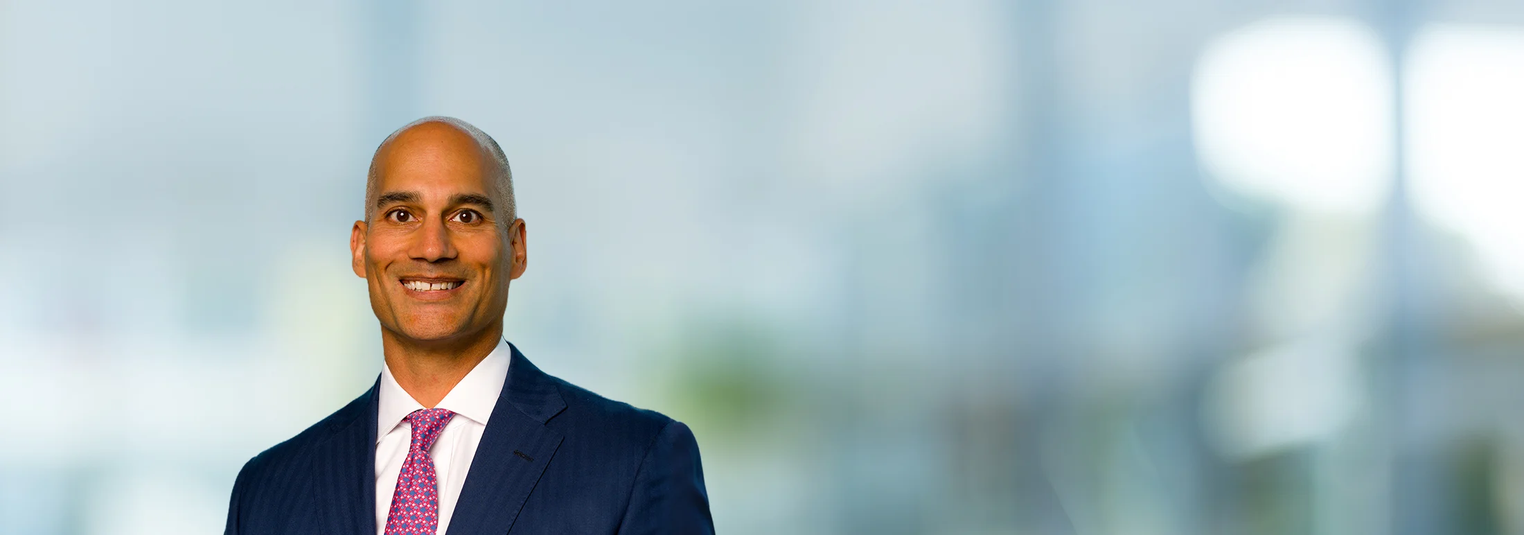 A photo of attorney Vijay Mago against a softly blurred office background