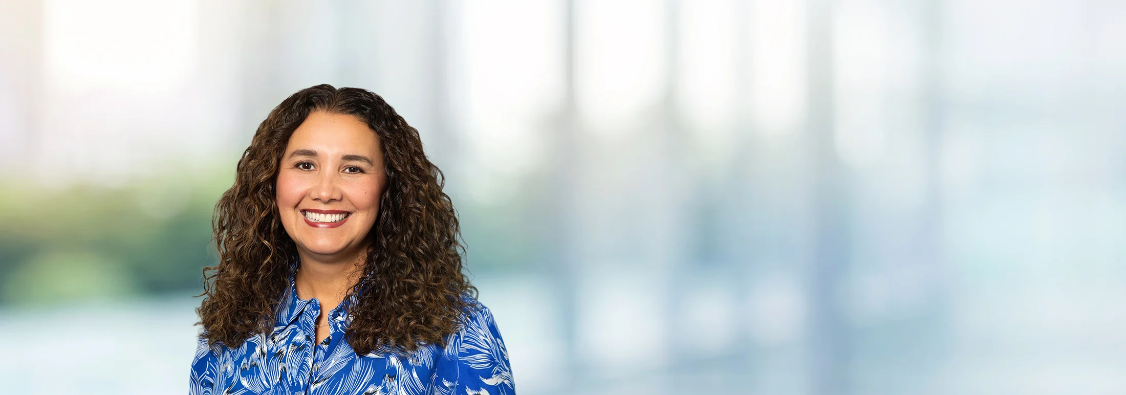 A photo of attorney Perla Duvel against a softly blurred office background