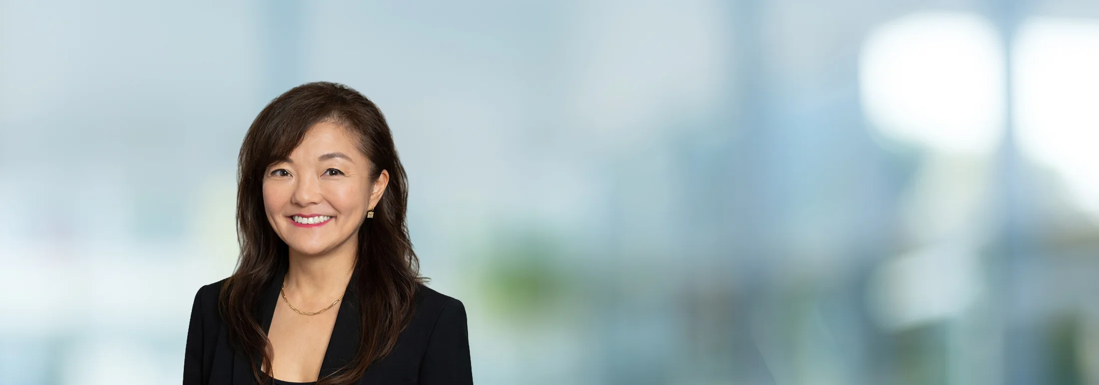 A photo of attorney Soojin Kang against a softly blurred office background