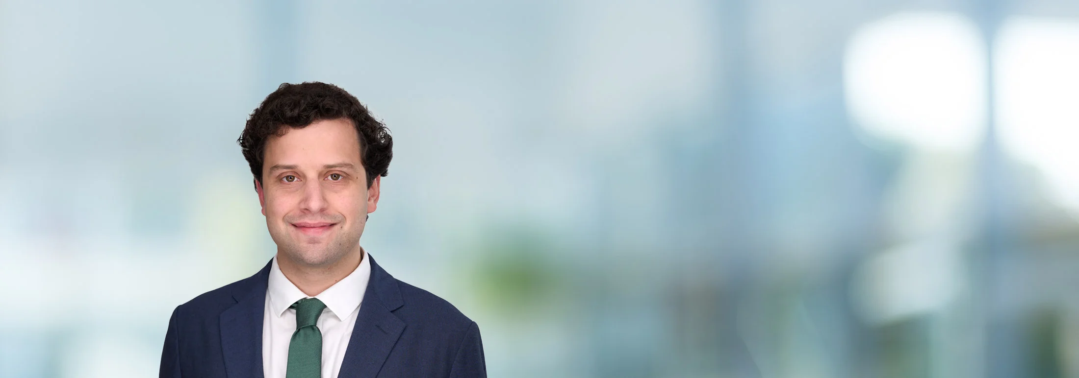 A photo of attorney Aidan Lee against a softly blurred office background