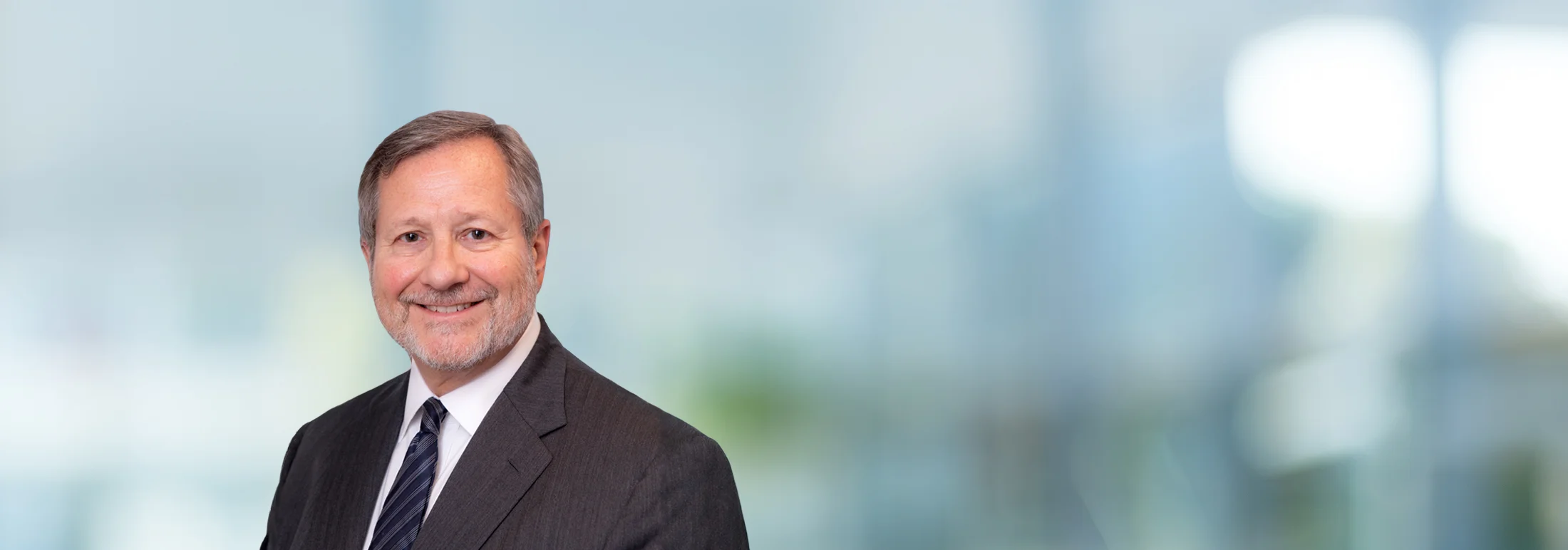 A photo of attorney, Mark Corner, against a softly blurred office background.