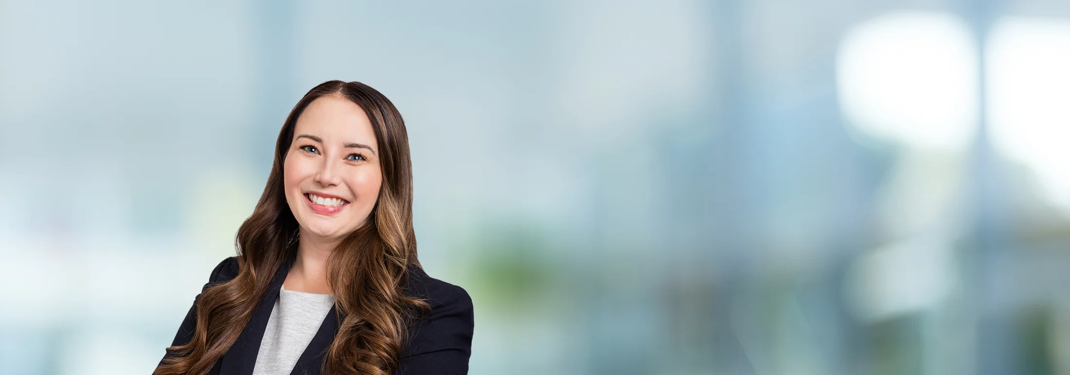 A photo of attorney, Alexa Perivolotis, against a softly blurred office background.