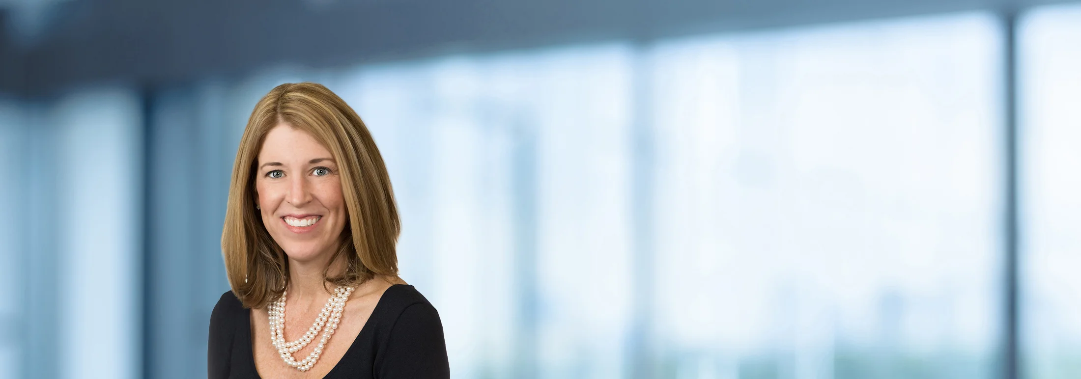 A photo of attorney, Paige Canepari, against a softly blurred office background.