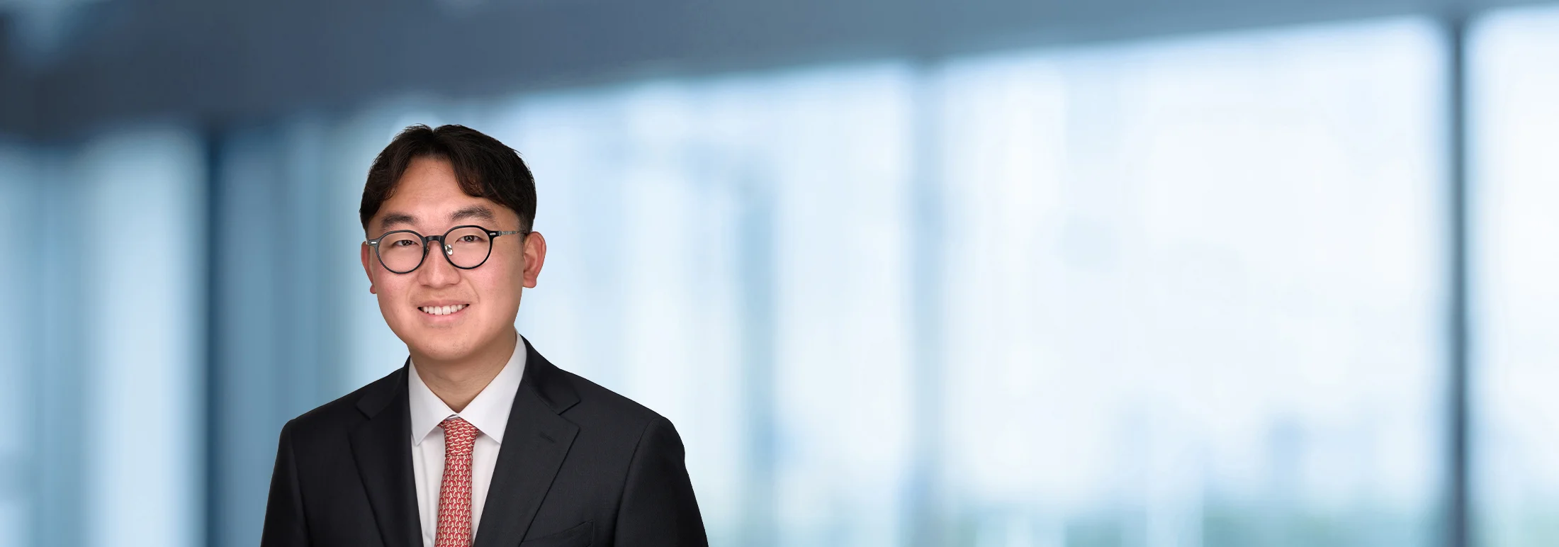 A photo of attorney Chongho Lee against a softly blurred office background