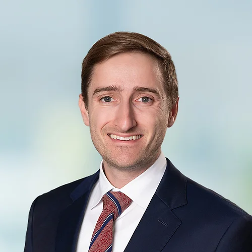 A photo of attorney, Connor Lynch, against a softly blurred office background.